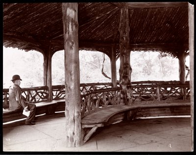 View of a Man Seated in a Rustic Landscape Pavilion in Central Park, New York, 1895 by Byron Company
